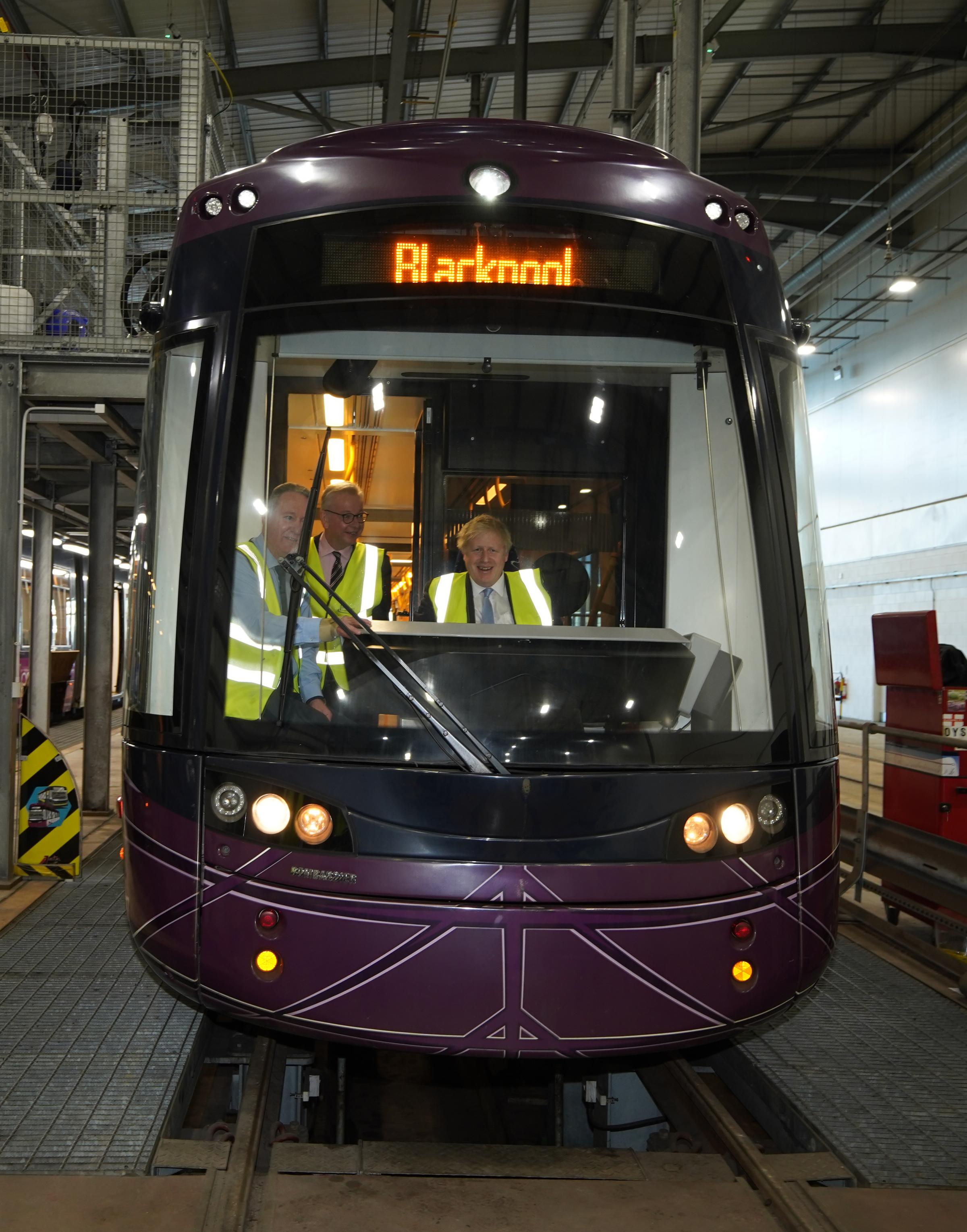 Prime Minister Boris Johnson (right) and Communities Secretary Michael Gove (centre) in the drivers cab of a tram during a visit to Blackpool Transport Depot