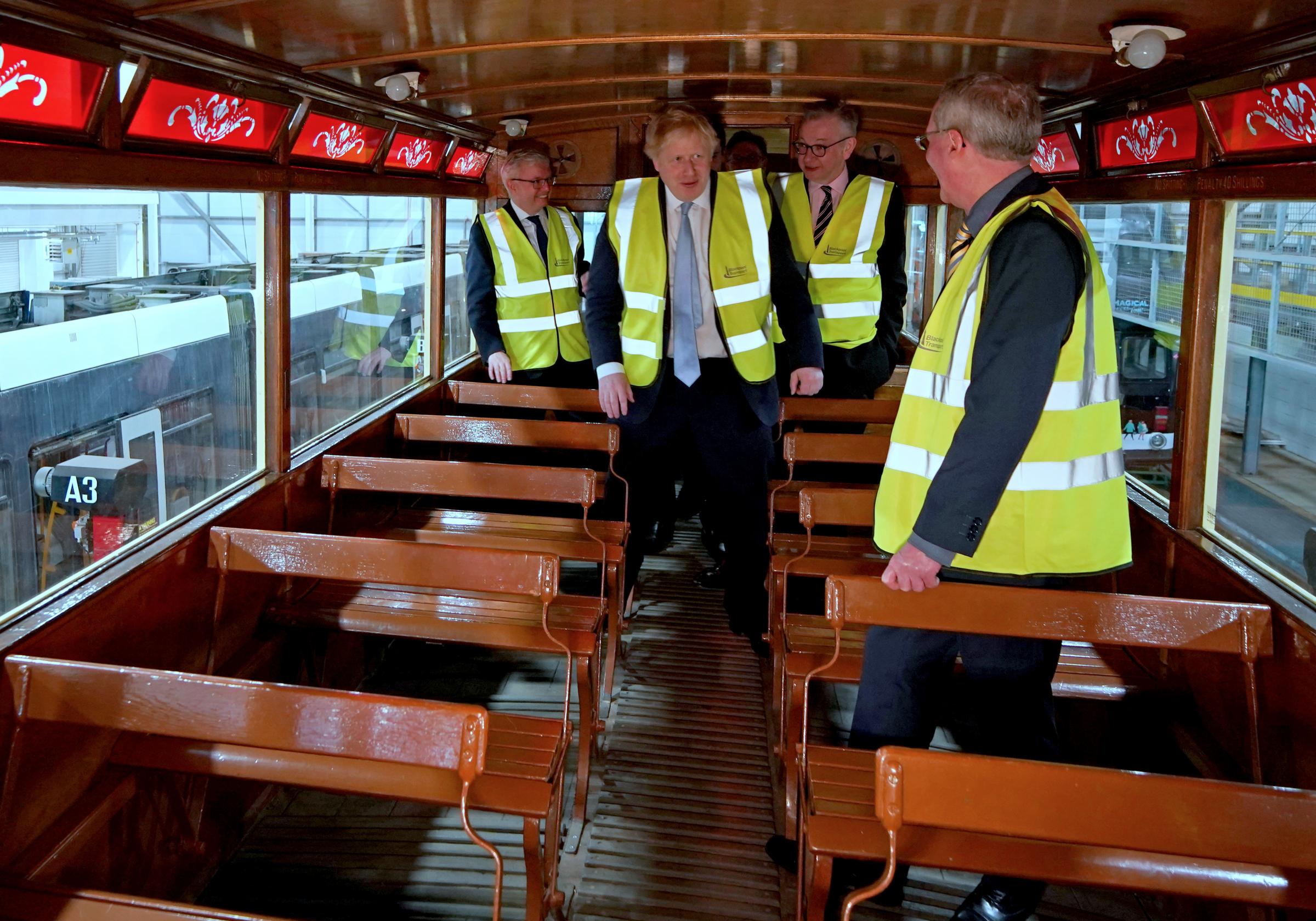 Prime Minister Boris Johnson (centre) and Communities Secretary Michael Gove (second right) viewing a vintage tram tram during a visit to Blackpool Transport Depot